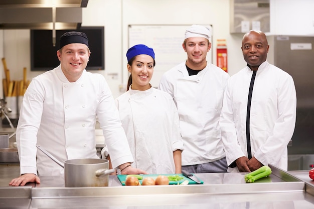 Bucătari zâmbind lângă aragaz